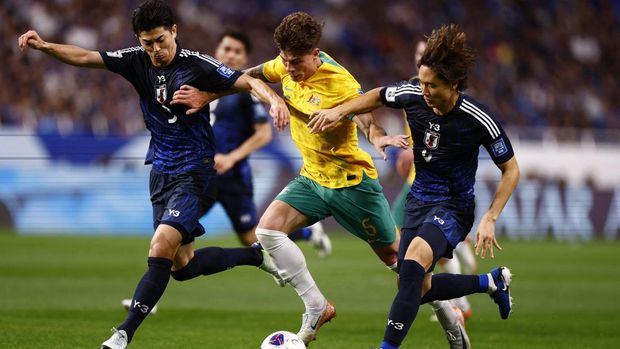 Jepang vs Australia Soccer Football - World Cup - Asian Qualifiers - Third Round - Group C - Japan v Australia - Saitama Stadium 2002, Saitama, Japan - October 15, 2024 Japan's Shogo Taniguchi and Japan's Ko Itakura in action with Australia's Jordan Bos REUTERS/Issei Kato