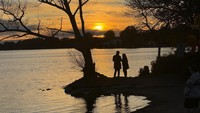 Wisatawan menikmati matahari tenggelam di tepi Danau Wilcox, Toronto, Senin (14/10/2024).