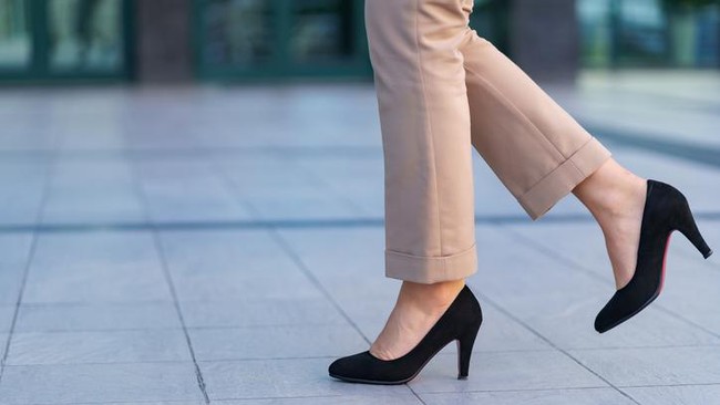Woman wearing classic black high heel toe shoes. Model posing on the street. Elegant outfit. Close up.