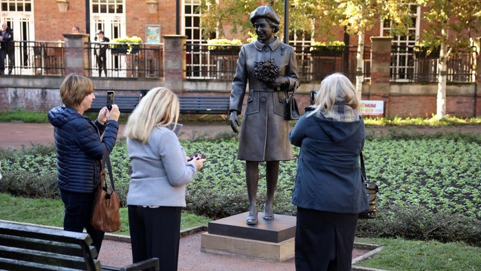 Patung Baru Ratu Elizabeth II Diresmikan di Newcastle People take photographs of a new statue of late Britain's Queen Elizabeth by artist Andy Edwards in Newcastle-under-Lyme, Britain, October 11, 2024. REUTERS/Phil Noble