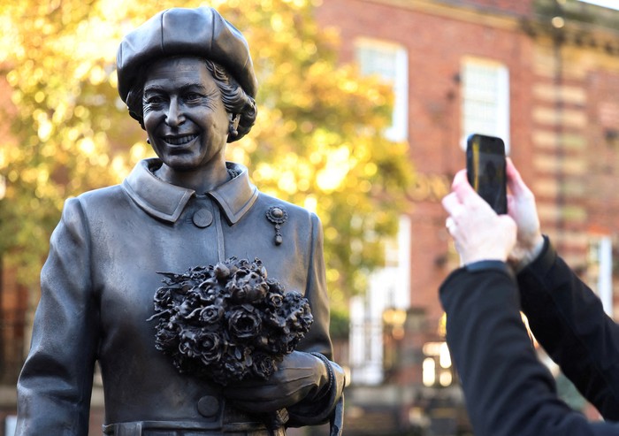 People take photographs of a new statue of late Britains Queen Elizabeth by artist Andy Edwards in Newcastle-under-Lyme, Britain, October 11, 2024. REUTERS/Phil Noble