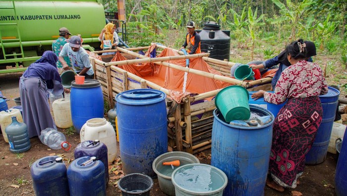 Warga mengambil air dari penampungan saat penyaluran bantuan air bersih di Desa Jenggrong, Kecamatan Ranuyoso, Lumajang, Jawa Timur, Selasa (15/10/2024). Pemerintah Kabupaten Lumajang melalui Badan Penanggulangan Bencana Daerah (BPBD) menyalurkan bantuan air bersih sebanyak sembilan armada tangki berkapasitas 5.000 liter ke 213 titik di 18 Desa terdampak kekeringan sejak tiga bulan terakhir. ANTARA FOTO/Irfan Sumanjaya/rwa.
