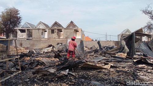 Petugas Damkar Denpasar melakukan pendinginan dan penanganan kebakaran areal gidang rongsokan di Jalan Pura Banyu Kuning, Desa Padangsambian Kelod, Kecamatan Denpasar Barat, Selasa (15/10/2024). (Aryo Mahendro/detikBali).