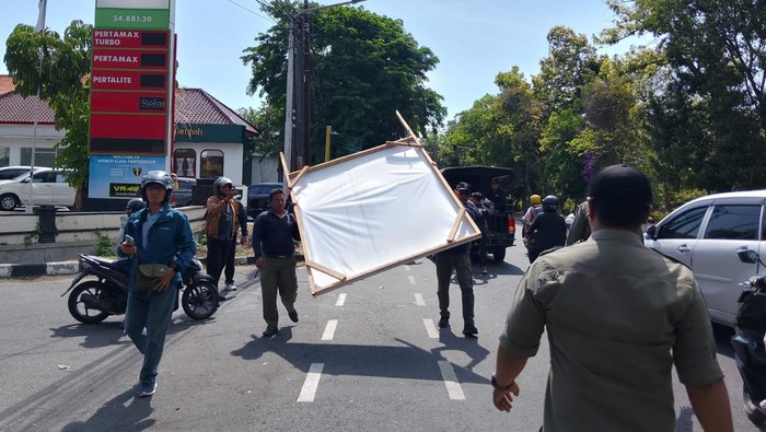 Petugas Satpol PP Kota Denpasar menurunkan sebanyak 52 alat peraga kampanye (APK) berupa baliho hingga spanduk di kawasan Denpasar, Bali, pada Senin (14/10/2024). (Foto: Dok. Satpol PP Denpasar)