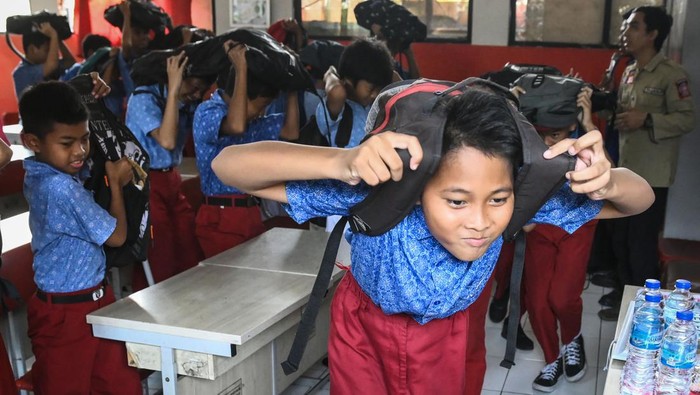 Semangatnya Siswa di Tangerang Ikut Simulasi Mitigasi Bencana Sejumlah siswa melindungi kepalanya dengan ransel saat mengikuti simulasi mitigasi bencana gempa di SDN Kedaung Wetan 2, Kota Tangerang, Banten, Selasa (15/10/2024). Anggota Taruna Siaga Bencana (Tagana) Kota Tangerang memberikan pengetahuan mitigasi bencana di lingkungan sekolah guna memperkuat kesiapsiagaan pelajar dalam menghadapi bencana. ANTARA FOTO/Sulthony Hasanuddin/nym.