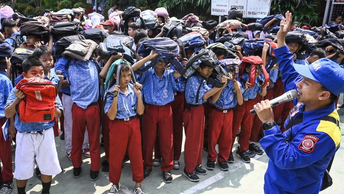 Sejumlah siswa melindungi kepalanya dengan ransel saat mengikuti simulasi mitigasi bencana gempa di SDN Kedaung Wetan 2, Kota Tangerang, Banten, Selasa (15/10/2024). Anggota Taruna Siaga Bencana (Tagana) Kota Tangerang memberikan pengetahuan mitigasi bencana di lingkungan sekolah guna memperkuat kesiapsiagaan pelajar dalam menghadapi bencana. ANTARA FOTO/Sulthony Hasanuddin/nym.