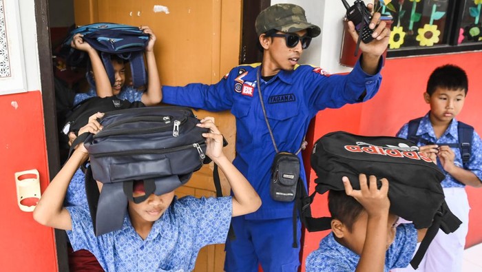 Sejumlah siswa melindungi kepalanya dengan ransel saat mengikuti simulasi mitigasi bencana gempa di SDN Kedaung Wetan 2, Kota Tangerang, Banten, Selasa (15/10/2024). Anggota Taruna Siaga Bencana (Tagana) Kota Tangerang memberikan pengetahuan mitigasi bencana di lingkungan sekolah guna memperkuat kesiapsiagaan pelajar dalam menghadapi bencana. ANTARA FOTO/Sulthony Hasanuddin/nym.