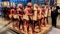 Seorang turis mengambil foto patung Firaun yang dipajang di Tangga Besar Museum Mesir Raya selama uji coba parsial di Giza, Mesir, Selasa (15/10/2024). 