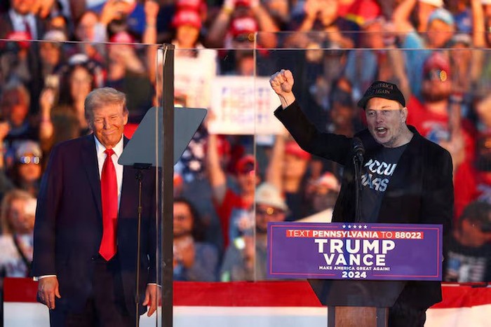 Tesla CEO and X owner Elon Musk speaks as Republican presidential nominee and former U.S. president Donald Trump looks on during a rally at the site of the July assassination attempt against Trump, in Butler, Pennsylvania, U.S., October 5, 2024. REUTERS/Carlos Barria/File Photo Purchase Licensing Rights