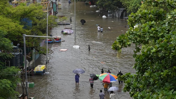 A women wades through a flooded street during heavy rain in Chennai, India, Tuesday, Oct.15, 2024. (AP Photo/Mahesh Kumar A.)