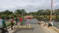 Intensitas hujan yang tinggi menyebabkan banjir dan sungai meluap di kabupaten setempat sehingga jembatan penghubung antar desa putus terbawa arus.  