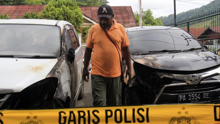 Seorang warga berjalan di sela mobil yang rusak akibat bom molotov di Halaman Kantor Redaksi Jubi, Waena, Kota Jayapura, Provinsi Papua, Rabu (16/10/2024). Aksi pelemparan bom molotov tersebut mengakibatkan dua mobil operasional Jubi yang diparkir di halaman kantor Redaksi Jubi terbakar dan rusak, sekitar pukul 03.15 WITA. ANTARA FOTO/Gusti Tanati/foc.
