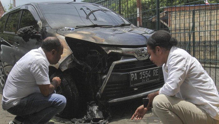 Kantor Redaksi Jubi Papua diserang bom molotov Seorang warga berjalan di sela mobil yang rusak akibat bom molotov di Halaman Kantor Redaksi Jubi, Waena, Kota Jayapura, Provinsi Papua, Rabu (16/10/2024). Aksi pelemparan bom molotov tersebut mengakibatkan dua mobil operasional Jubi yang diparkir di halaman kantor Redaksi Jubi terbakar dan rusak, sekitar pukul 03.15 WITA. ANTARA FOTO/Gusti Tanati/foc.