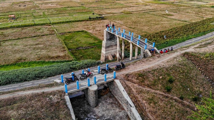 Kondisi waduk mengering di Nganjuk Foto udara sejumlah warga duduk di tepi Waduk Perning yang mengering di Nganjuk, Jawa Timur, Rabu (16/10/2024). Sejak lima bulan terakhir, waduk yang berfungsi untuk perikanan, wisata, dan irigasi seluas sekitar 200 hektar lahan pertanian itu mengering akibat musim kemarau. ANTARA FOTO/Muhammad Mada/foc.