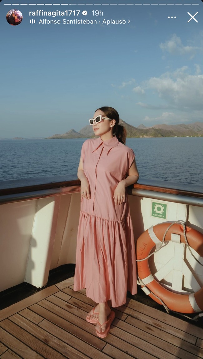 Nagita Slavina tampil cantik dalam balutan dress merah muda dan sandal warna senada. Penampilannya dilengkapi dengan kaca mata hitam. Foto: Instagram