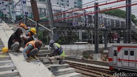 Tampak kereta melintas di bawah JPO yang tengah dibangun.
