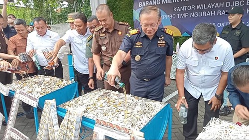 Petugas Bea Cukai memusnahkan belasan ribu batang rokok ilegal dengan disiram miras, Rabu (16/10/2024). (Aryo Mahendro/detikBali)