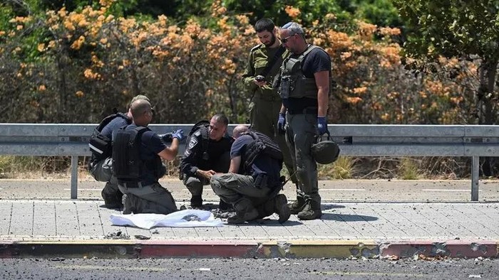 Israeli police and a soldier work at the impact site of a projectile, after Lebanon’s armed group Hezbollah said it launched a swarm of attack drones against military targets in northern Israel, in Nahariya, Israel, on August 6, 2024. (Reuters)
