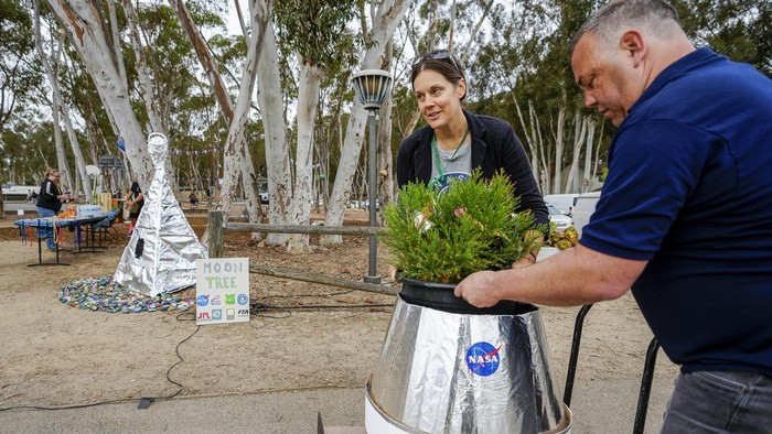 Sekolah California Tanam Pohon Bulan Dukung Pendidikan Sains dan Konservasi Santiago parent volunteer Stacie Aguesse, right, helps students plant a small Giant Sequoia tree from NASA's Artemis I Mission's treeΒ seeds that traveled around the moon twice, as NASA scientists, JPL engineers, US Forest Service representatives, and teachers join Santiago STEAM Magnet Elementary School students at a ceremony to plant it after the school was honored in the spring of 2024 to becomeΒ NASA Moon Tree Stewards in Lake Forest, Calif., on Monday, Oct. 14, 2024. (AP Photo/Damian Dovarganes)