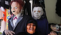 Seorang penjual topeng berpose untuk foto sambil mengenakan topeng Halloween mantan Presiden Bolivia Evo Morales di sebuah toko kostum di La Paz, Bolivia, Selasa (15/10/2024).