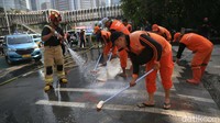 Petugas gabungan membersihkan trotoar di Jalan Jenderal Sudirman, Jakarta, Kamis (17/10/2024).  