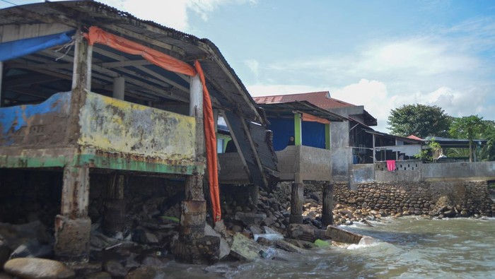 Kendaraan melintas di dekat pagar tembok yang roboh akibat diterjang gelombang pasang di pantai Padang, Sumatera Barat, Kamis (17/10/2024). Gelombang pasang dan abrasi menerjang pesisir pantai di kota itu membuat sejumlah bangunan dan fasilitas umum rusak.  ANTARA FOTO/Iggoy el Fitra/tom.