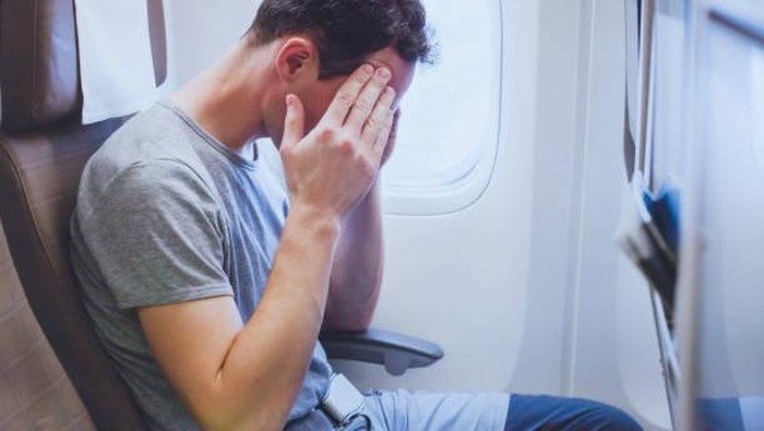 headache in the airplane, man passenger afraid and feeling bad during the flight in plane