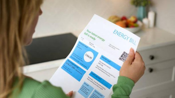 Close Up Of Woman Opening American Dollar Energy Bill During Cost Of Living Crisis