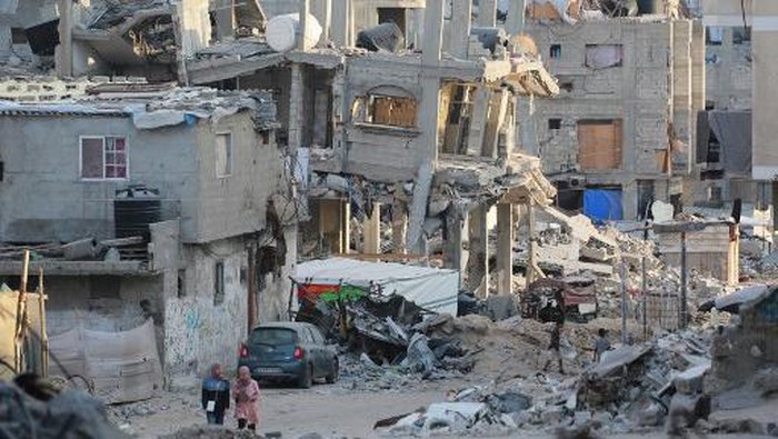 A car drives past destroyed buildings in Khan Yunis in the southern Gaza Strip on October 17, 2024, amid the ongoing war between Israel and the Palestinian militant group Hamas in the besieged Palestinian territory. (Photo by BASHAR TALEB / AFP)