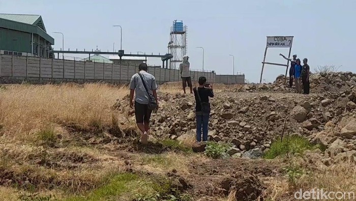 Warga di lokasi saluran drainase yang tertutup tanah uruk pabrik, Kamis (17/10/2024).