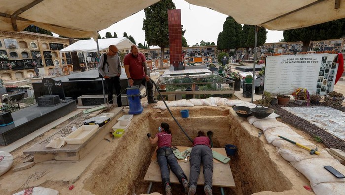 Antoni Antoni Balanca, 57, and Jesus Espinos Andres, 33, of the Association of Relatives of Victims of the Mass Grave 96, pose during the exhumation of the last mass graves containing remains of people shot by dictator Francisco Franco's forces in 1939, at the in the cemetery in Paterna, Spain, October 14, 2024. REUTERS / Eva Manez