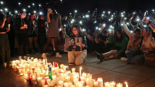 A woman holds a poster with an image of Liam Payne next to other One Direction fans as they gather to pay tribute to Liam Payne, at the Monument of the Revolution, in Mexico City, Mexico October 17, 2024. REUTERS/Henry Romero