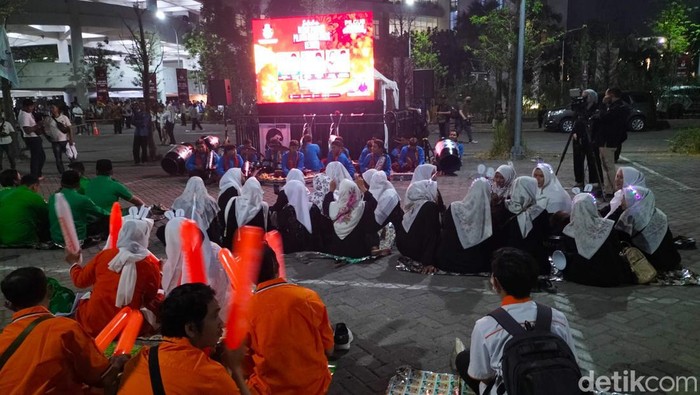 pendukung paslon 2 khofifah-emil melihat layar lebar di lokasi debat perdana pilgub jatim