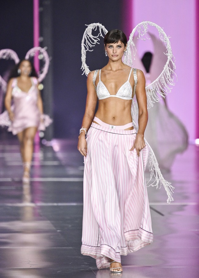 Taylor Hill juga memesona dengan padanan lingerie putih dan rok pink. Sayap sederhana ikut menemani gayanya. (Foto: Evan Agostini/Invision/AP)