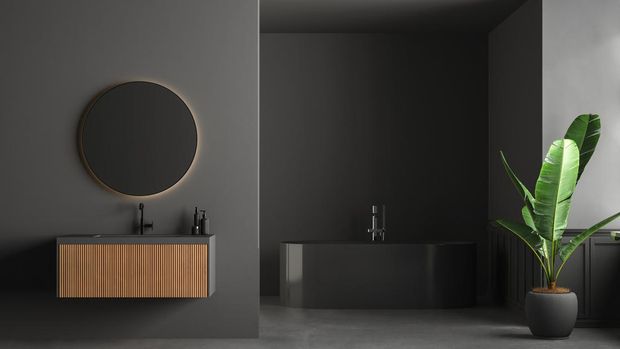 Dark bathroom interior with concrete floor, black bathtub, and oval mirror standing on black wall. Minimalist black bathroom with modern furniture. 3D Rendering
