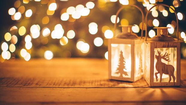 Close-up of lanterns with candles on wooden background. Sparkling lights in background.  Evening or night scenes.