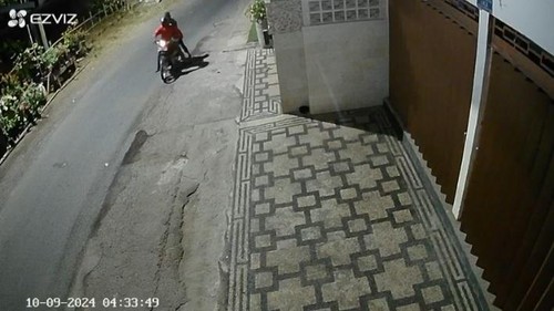 Dua orang yang mengendarai sepeda motor terekam kamera pemantau atau CCTV saat sedang meracuni anjing di depan rumah warga. (Tangkapan layar)