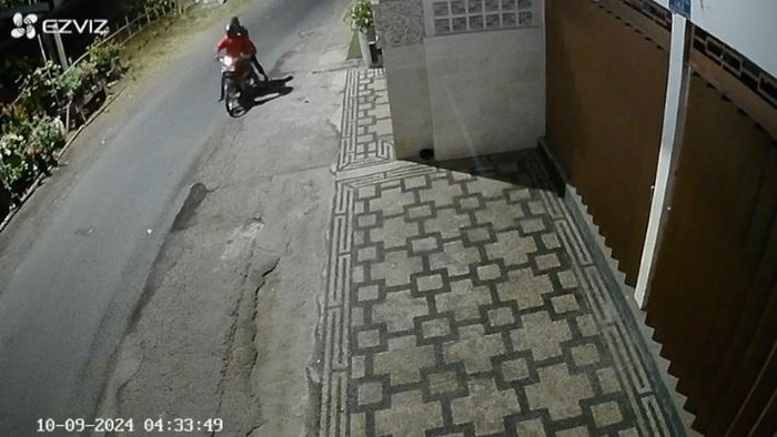 Dua orang yang mengendarai sepeda motor terekam kamera pemantau atau CCTV saat sedang meracuni anjing di depan rumah warga. (Tangkapan layar)