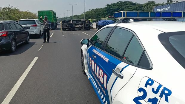 Foto truk box terguling di jalan tol
