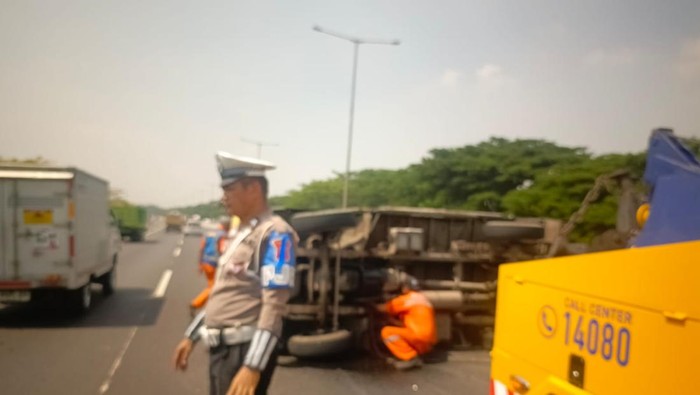 Foto truk box terguling di jalan tol