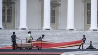 Pekerja menyiapkan karpet merah untuk acara pisah sambut presiden di halaman Istana Merdeka, Jakarta, Sabtu (19/10/2024).