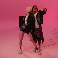 Bruno Mars tak kalah tampil atraktif. Musisi yang populer dengan lagu ’The Lazy Song’ ini juga tampil dengan jaket stud, kaus putih dan celana bermuda dengan kemeja flanel yang dililit di pinggang sebagai aksen. Foto: Screenshot YouTube/ROSE