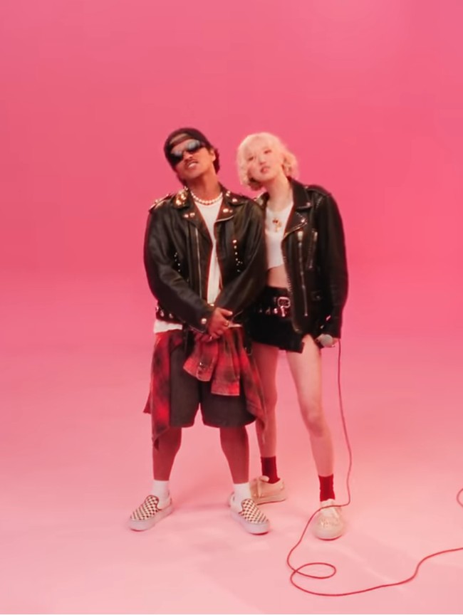 Penyanyi 27 tahun ini mengenakan jaket kulit biker dengan detail stud, dipadukan dengan skort dan sneakers putih yang edgy sekaligus chic. Foto: Screenshot YouTube/ROSE