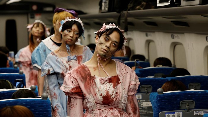 People dressed as zombies perform inside a 