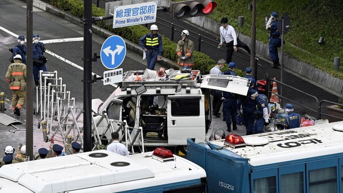 Police investigate a car stuck against a fence, near the entrance to the Prime Minister's Office in Tokyo, Japan October 19, 2024, in this photo taken by Kyodo. Mandatory credit Kyodo/via REUTERS ATTENTION EDITORS - THIS IMAGE WAS PROVIDED BY A THIRD PARTY. MANDATORY CREDIT. JAPAN OUT. NO COMMERCIAL OR EDITORIAL SALES IN JAPAN. TPX IMAGES OF THE DAY