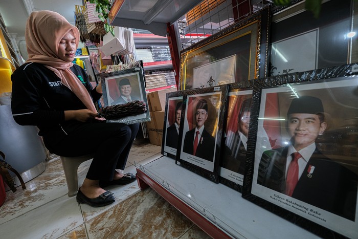 Penjualan Foto Resmi Prabowo-Gibran Meningkat Drastis Pekerja menunjukkan foto Presiden dan Wakil Presiden terpilih Prabowo Subianto dan Gbran Rakabuming Raka sebelum dibingkai di salah retail di Kendari, Sulawesi Tenggara, Minggu (20/10/2024). Pemilik retail mengaku sejak H-2 hingga hari H pelantikan, mereka dapat menjual foto Presiden dan Wakil Presiden terpilih masa bakti 2024-2029 tersebut hingga puluhan set perhari yang dijual Rp100 ribu per set. ANTARA FOTO/Andry Denisah/YU