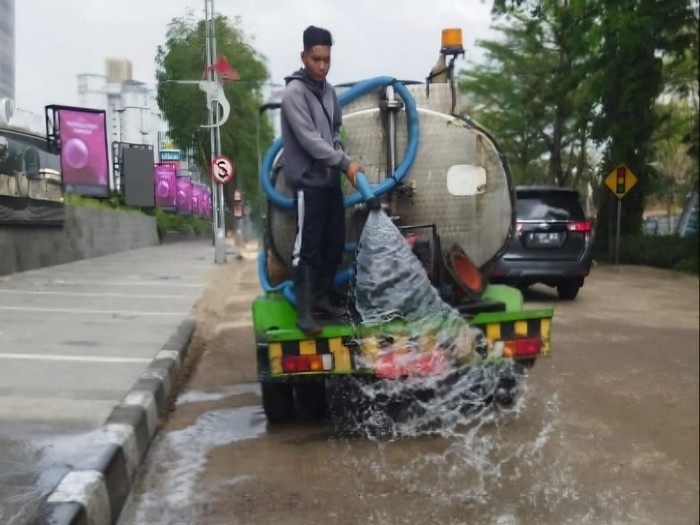Penyiraman untuk mengurangi debu di proyek jalan di Surabaya