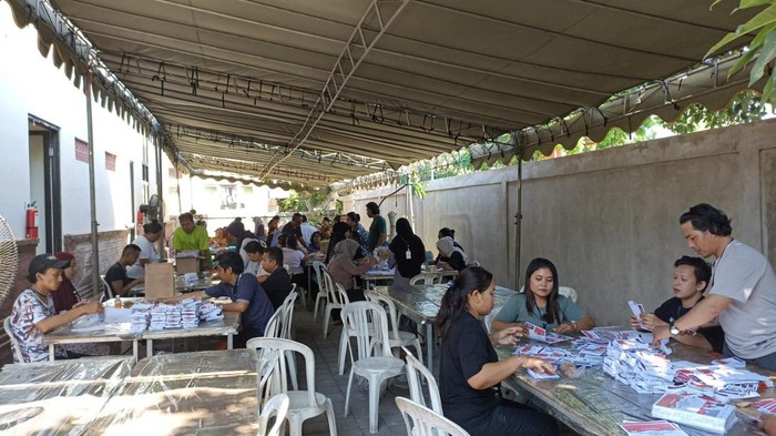 Sejumlah relawan melakukan sortir dan pelipatan surat suara di gedung Padepokan Perisai Diri, Tembau, Denpasar, Bali, pada Minggu (20/10/2024). (Foto: Dok. KPU Kota Denpasar)