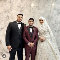 Turut hadir di acara resepsi sang kakak, Fadil tampil mengenakan setelan jas berwarna merah. Ia pun berpose bersama kedua mempelai. Foto: Instagram