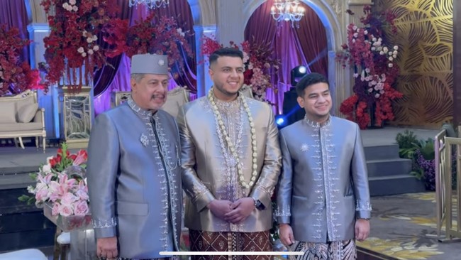 Di acara akad nikah, Yislam tampil mengenakan busana pengantin bernuansa coklat. Sementara ayah dan adiknya, Muhammad Jaidi dan Fadil Jaidi kompak mengenakan busana berwarna abu-abu. Foto: YouTube/Fadil Jaidi